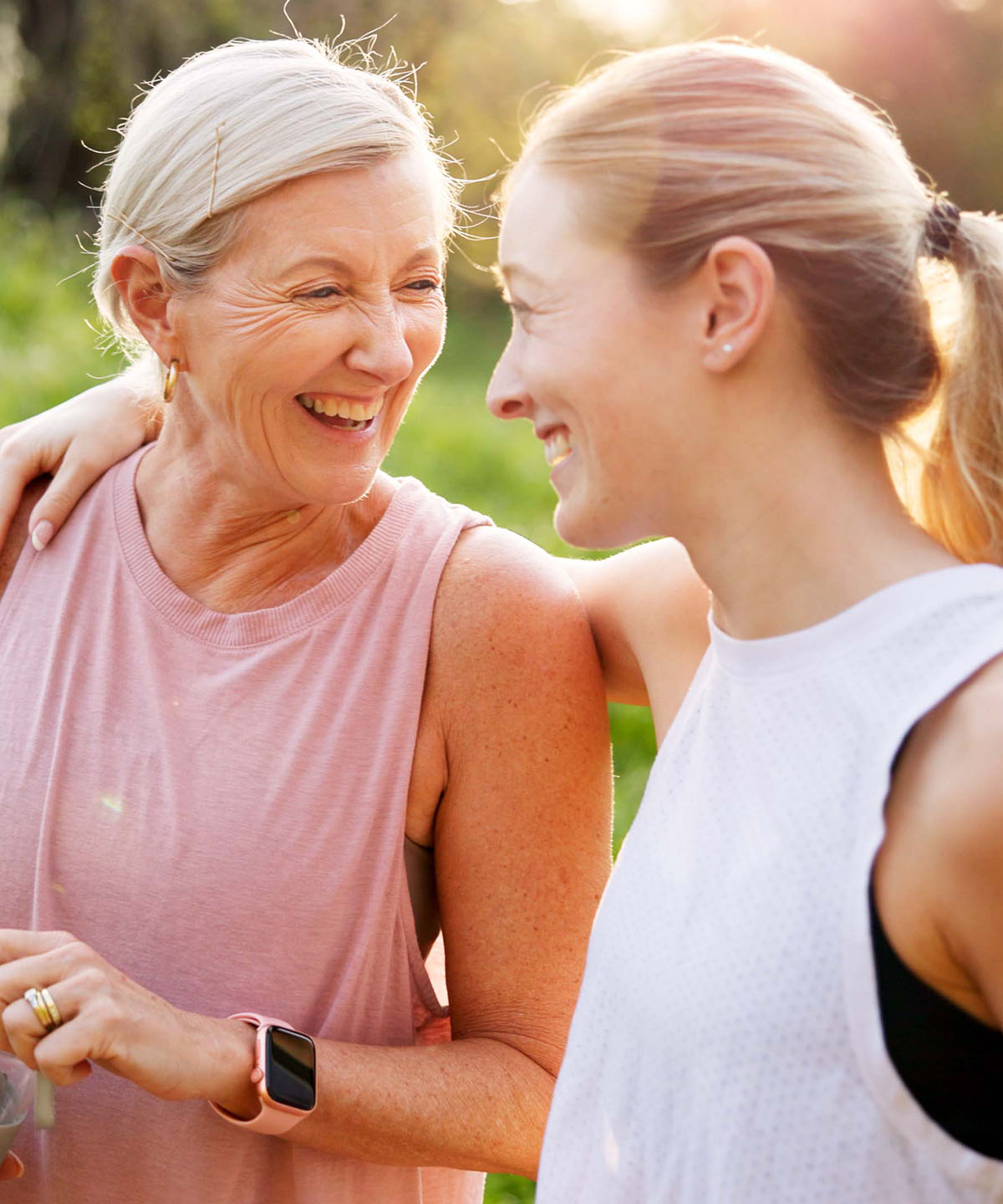 Two women laughing together, arm around shoulder